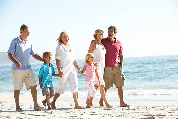 tre generazione famiglia camminare sulla spiaggia - grandfather adult affectionate little boys foto e immagini stock