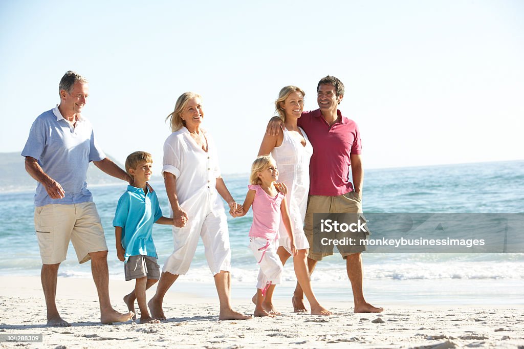 Three Generation Family Walking On Beach  Beach Stock Photo
