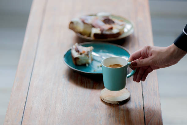 istock hand holding cup near pate with eaten cake 1042887838