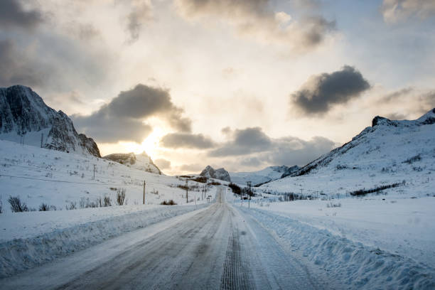 istock Dirty snow road with sunlight on mountains 1042891744