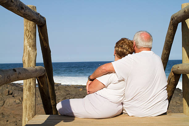 istock senior couple cuddling on beach 104289958