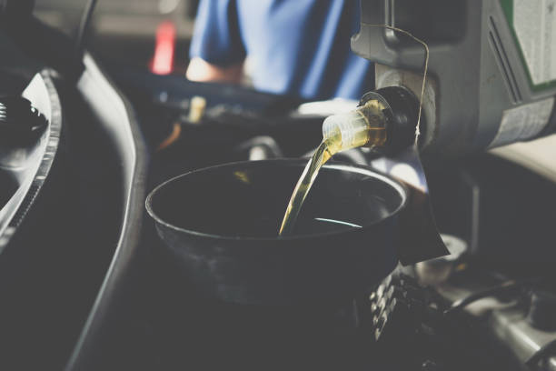 istock Car mechanic fills a fresh lubricant engine oil 1042904302