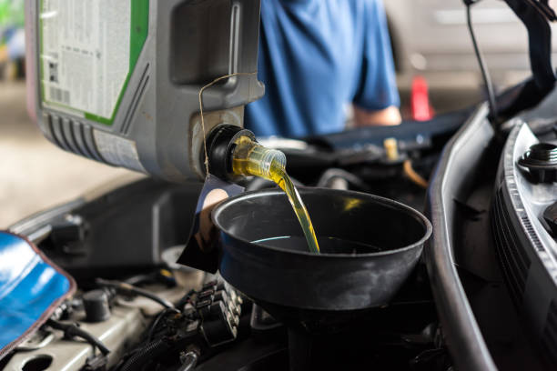 istock Car mechanic fills a fresh lubricant engine oil 1042904310