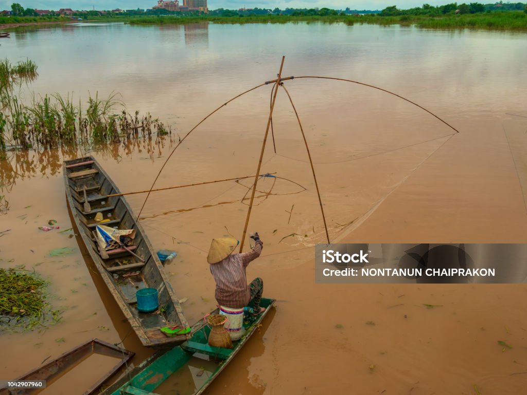 Fisherman In The Mekong With Ancient Fishing Tools Stock Photo