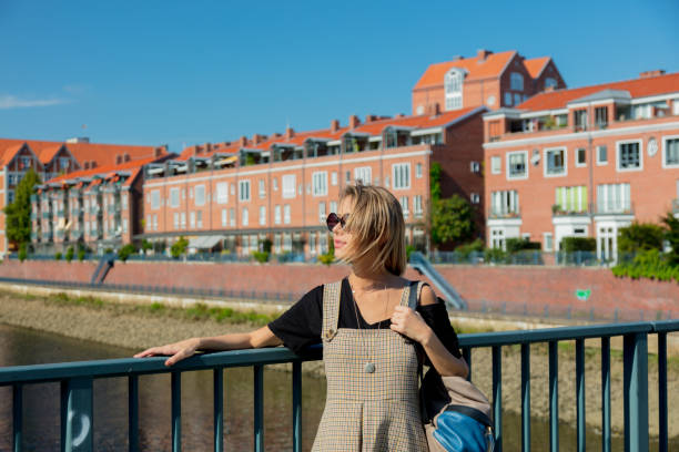 istock Young girl stay on a bridge with Bremen on background 1042913600