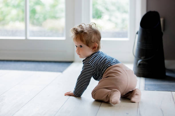 Little baby boy have a fun on a floor on a house near a window.