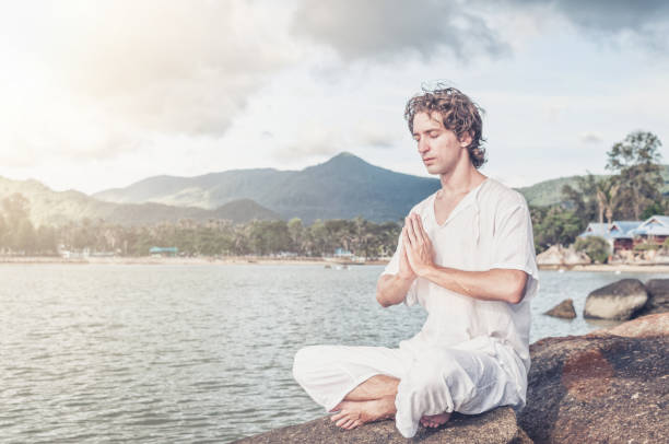 istock Young man meditating  on the beach 1042914600