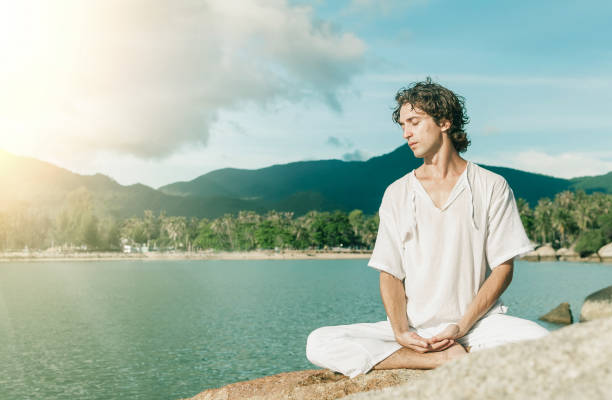 istock A young man meditates on a rocky beach 1042914670