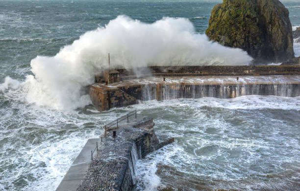 Waves batter the harbour, Mullion Cove, Cornwall Waves batter the harbour, Mullion Cove, Cornwall mullion cove stock pictures, royalty-free photos & images