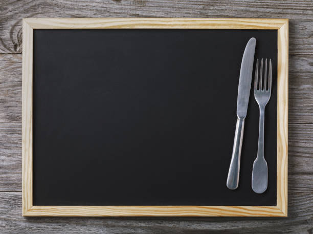 istock Empty menu blackboard with knife and fork on wooden background with copy space 1042921164