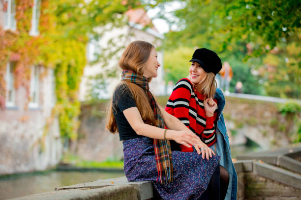 istock Young girlfriends talking on bridge in Bruges 1042923668