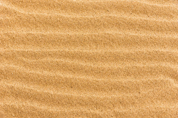 istock Beach sand with stripes from the waves - natural background with copy space 1042927718