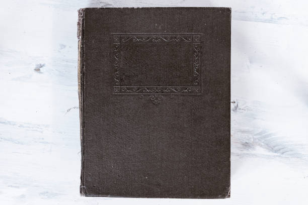 istock Old book with a damaged brown cover on a light background 1042932868