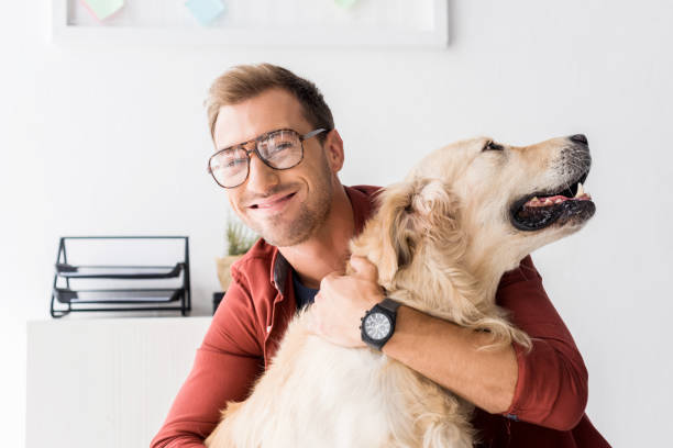 istock smiling man hugging golden retriever dog 1042933112