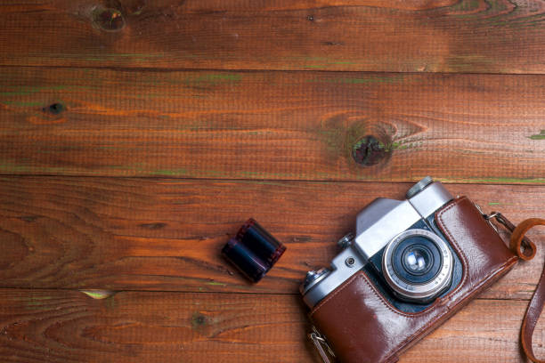 istock Old retro camera on vintage wooden boards abstract background. Copy space for text 1042933212