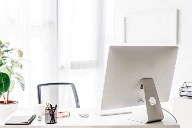 istock computer monitor and office supplies on white table 1042933450