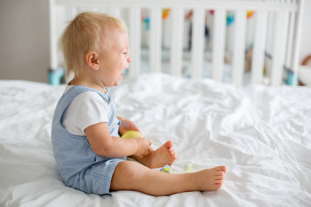 istock Toddler baby boy, playing with dummy, crying unhappy for the pacifier 1042936284