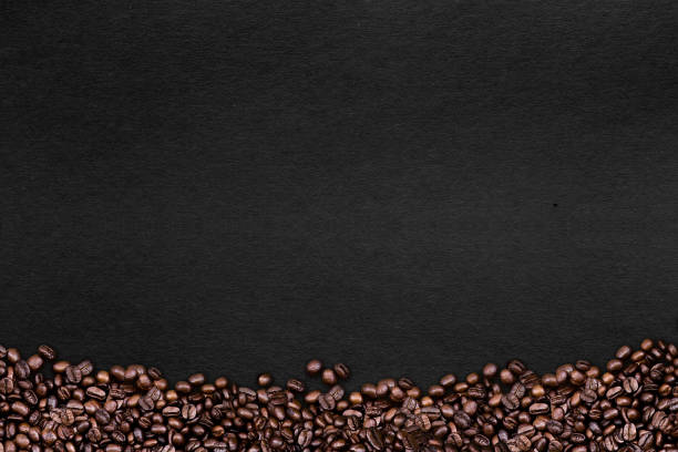 istock coffee bean on black paper background, top view 1042945588