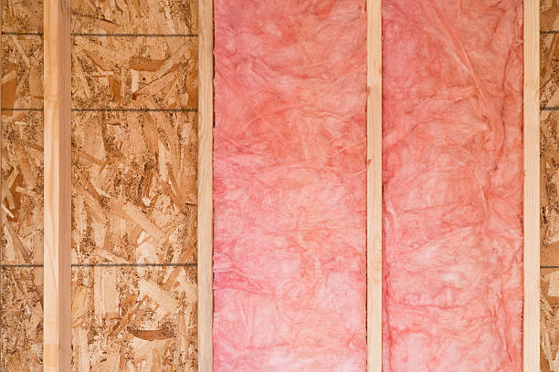 New Wall With Fiberglass Insulation Close-up of strips of pink fiberglass insulation in a wall of a new building. Horizontal shot. insulation stock pictures, royalty-free photos & images