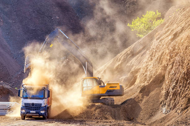 pelle et camion pour chantier de construction. excavation est le processus de déplacement de la terre, de plâtre ou d’autres matériaux avec des outils, de matériel ou d’explosifs. il inclut des travaux de terrassement, tranchées, mur et le tunneli - rock quarry photos et images de collection