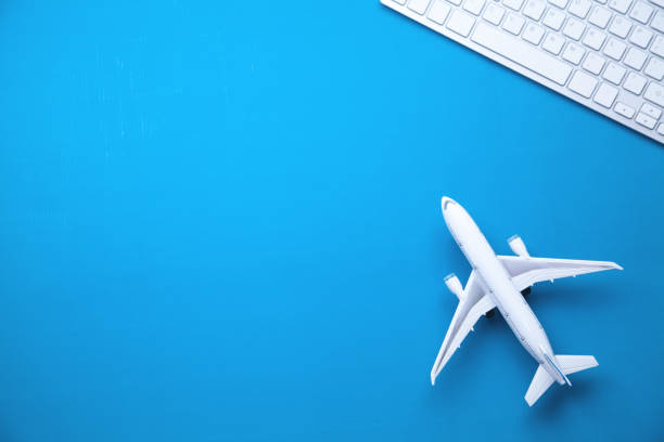 istock Airplane and computer keyboard on blue background. Travel and planning concept 1042964426