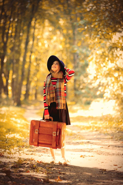 istock girl with suicase in a park 1042964510