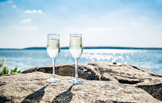 romantic trip on the Mediterranean coast in Italy. Two glasses of champagne against the background of the sunny sea landscape