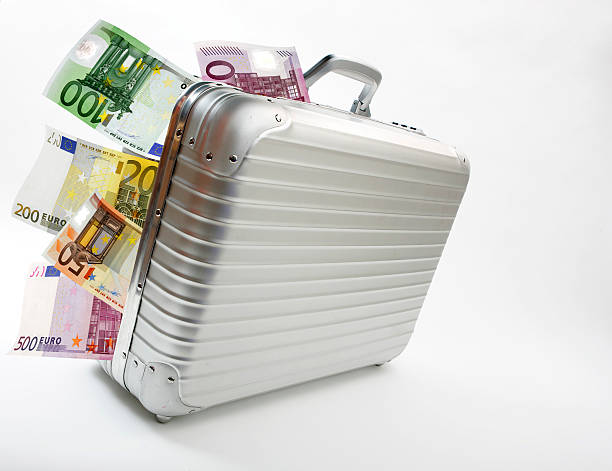 istock Shiny silver briefcase with foreign money sticking out 104297848