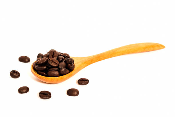 Coffee beans with wooden spoon on white background. Composition isolated over the white background.