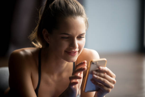 istock Young sporty woman using mobile phone after practicing yoga 1042985040