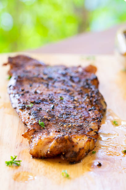 Steak with fries and sauce on a wooden tray