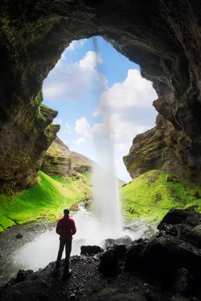 Photo of Tourist looks at the big waterfall in Iceland