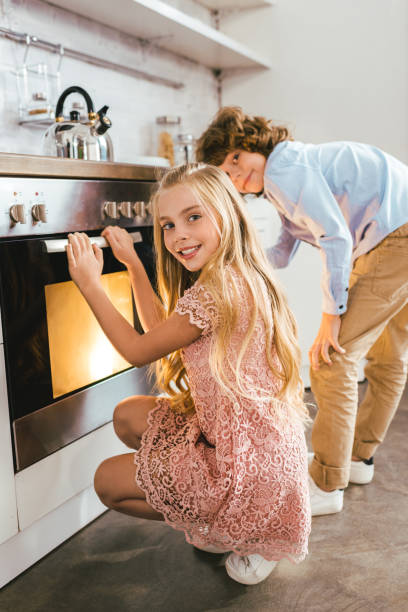istock happy adorable siblings standing near oven at kitchen 1042994006