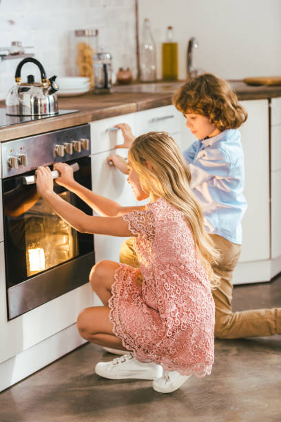 istock adorable kids looking at baking oven at kitchen 1042994012