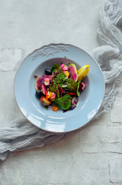istock Salad with vegetables, herbs and lemon on in a blue plate on a gray background. 1042998528