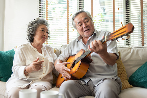 Happy Retirement Older Couple enjoying with singing and guitar together. Having fun.