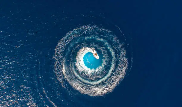 Photo of A boat is driving in a circle and produces a big whirlpool