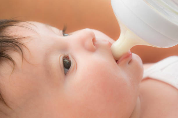 istock newborn baby sucking bottle 1043008172