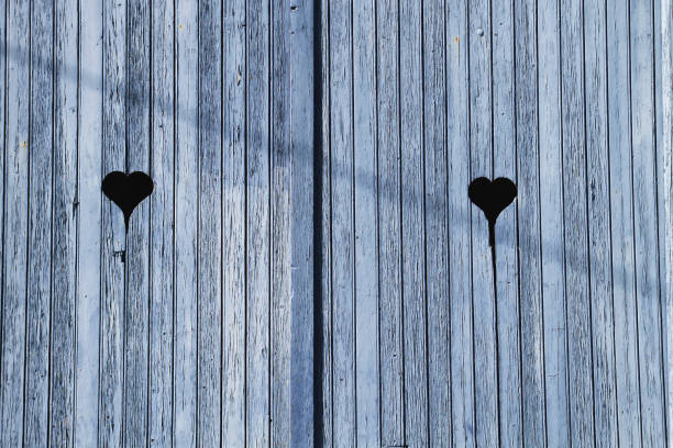 Metal heart shape decoration on an old modernist crimson door locked detail