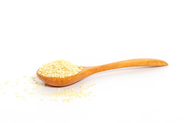 istock Sesame seeds with wooden spoon on white background. Composition isolated over the white background. 1043016638