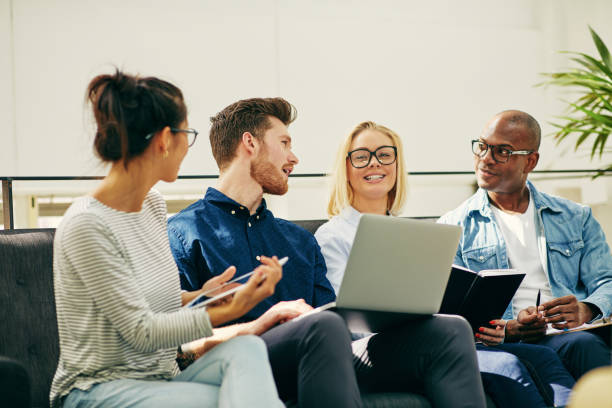 istock Smiling young businesspeople talking together on an office sofa 1043031492