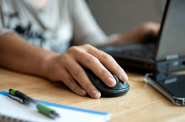 istock Office girl hand are usingmouse to operate laptop. 1043032410
