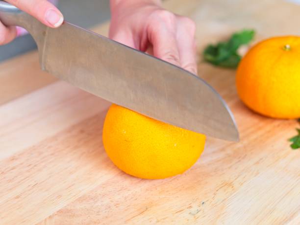 istock Cutting a orange that placed on wooden chopping board 1043058164