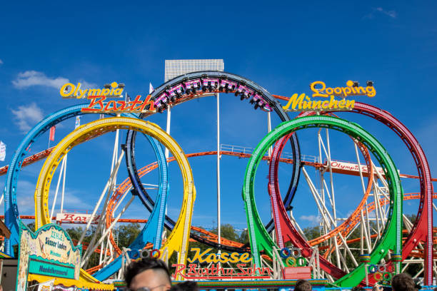 rollercoaster olympia looping all'oktoberfest di monaco di baviera con cielo azzurro - ferris wheel wheel oktoberfest carnival foto e immagini stock