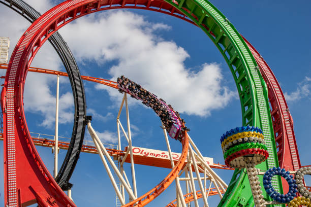 rollercoaster olympia looping on the oktoberfest in munich with blue sky - ferris wheel fotos imagens e fotografias de stock