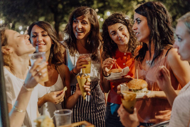 istock Happy friends having fun together, eating hamburger and drinking beer 1043062530