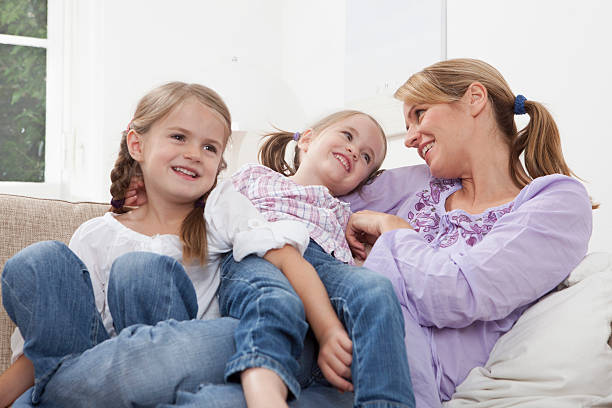 istock Germany, Munich, Mother with daughters (4-7) resting on sofa 104306509
