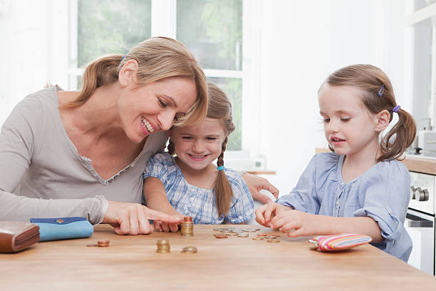 istock Germany, Munich, Mother with daughters (4-7) counting stack of coins 104306512