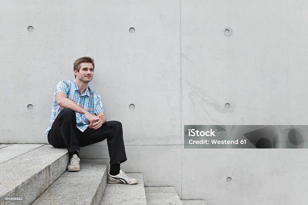 Sorrindo médio caucasiano adulto homem sentado na escada em Berlim - Foto de stock de Degraus royalty-free