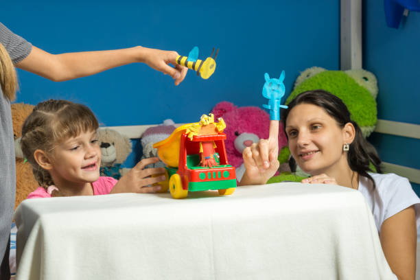 istock An enthusiastic mother plays with daughters in a self-made finger puppet theater 1043070514